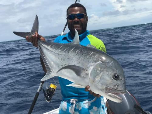 a man holding a large fish in the ocean at Oneta Resort in Ono Island