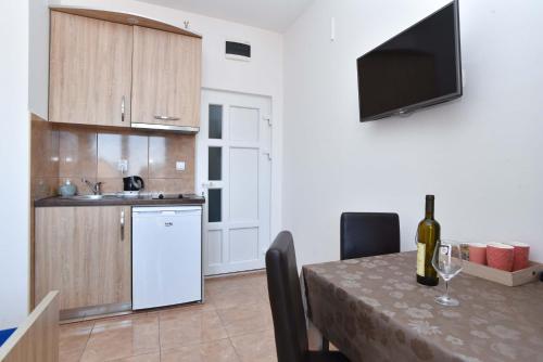 a kitchen with a table with a bottle of wine at Apartments Jelušić in Budva