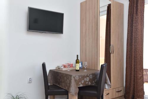 a table with two chairs and a television on a wall at Apartments Jelušić in Budva