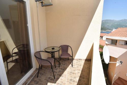 a balcony with chairs and a table on a floor at Apartments Jelušić in Budva