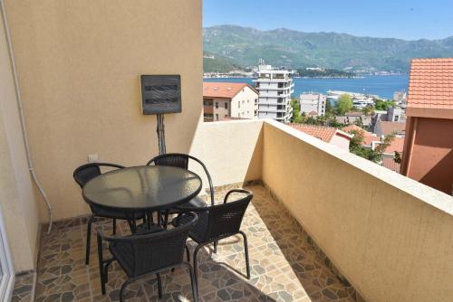 a balcony with a table and chairs on a building at Apartments Jelušić in Budva