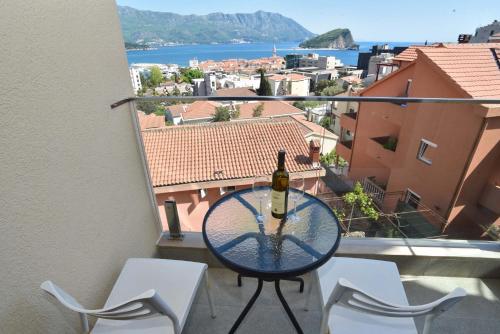 a bottle of wine sitting on a table on a balcony at Apartments Jelušić in Budva