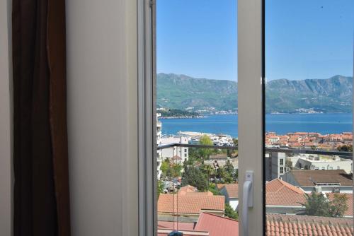 a window with a view of a city and water at Apartments Jelušić in Budva