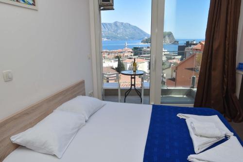 een slaapkamer met een bed en uitzicht op de oceaan bij Apartments Jelušić in Budva