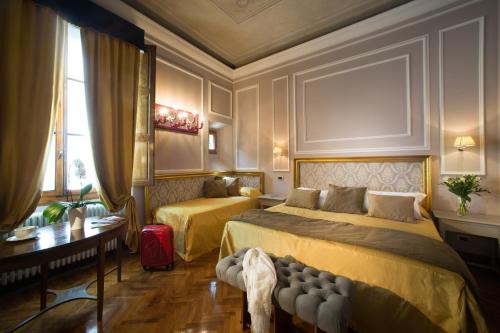 a bedroom with a bed and a desk and a window at Boutique B&B Torre de' Conti in Florence