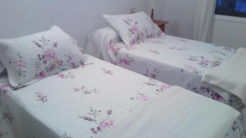 El PuertitoにあるBajamar frente al marのベッド2台(白いシーツ、ピンクの花付)