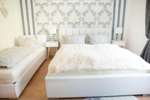 a white bedroom with a bed and a couch at Rust-Fewo-Hotel in Rust