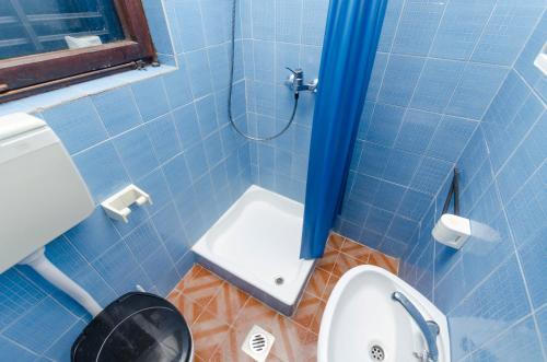 a blue tiled bathroom with a toilet and a shower at Apartments Milena in Rtina