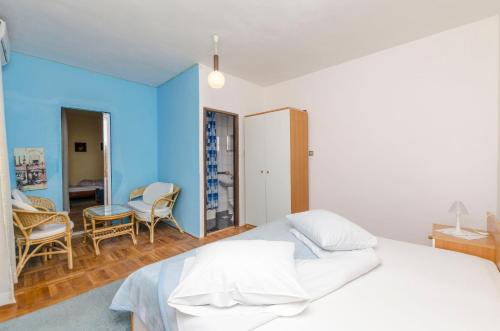 a bedroom with a white bed and a blue wall at Apartments Milena in Rtina