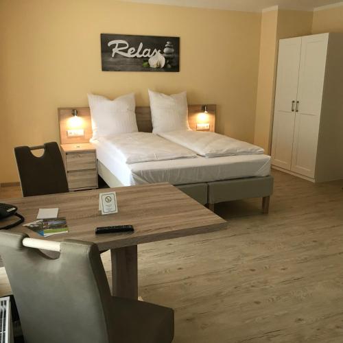 a hotel room with a bed and a table and a desk at Hotel Select Suites & Aparts in Mönchengladbach