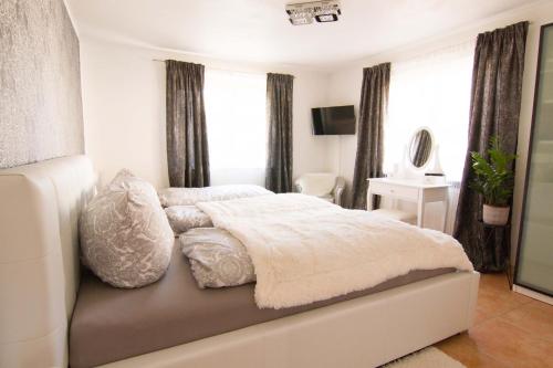 a bedroom with a bed with white blankets and pillows at Rust-Fewo-Hotel in Rust