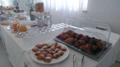 une table blanche avec un buffet de nourriture dessus dans l'établissement Malucri Resort, à San Giovanni Rotondo