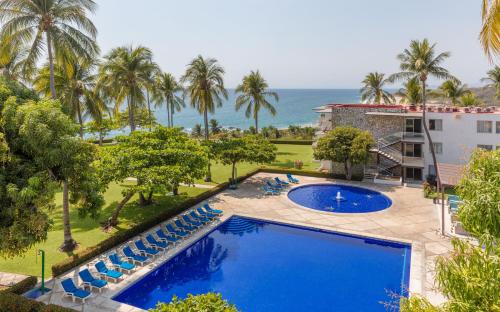 an aerial view of a resort with a pool and palm trees at Posada Real Puerto Escondido in Puerto Escondido