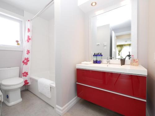 a bathroom with a red sink and a toilet at Gîte Zazen in Mont-Laurier