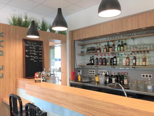 a bar with a counter with bottles of alcohol at Le Felicien in Saint-Félicien
