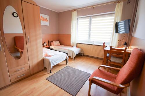 ボウォミンにあるHotel U Stefaniakówのベッドと机と鏡のある寝室
