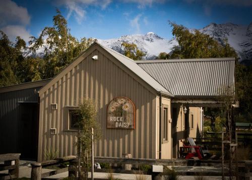 a building with a snow covered mountain in the background at The Headwaters Eco Lodge in Glenorchy