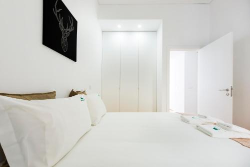 - une chambre blanche avec un lit blanc et une fenêtre dans l'établissement The Trendy Prince Lisbon Apartment, à Lisbonne