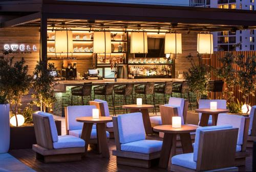 a restaurant with tables and chairs and a bar at 'Alohilani Resort Waikiki Beach in Honolulu