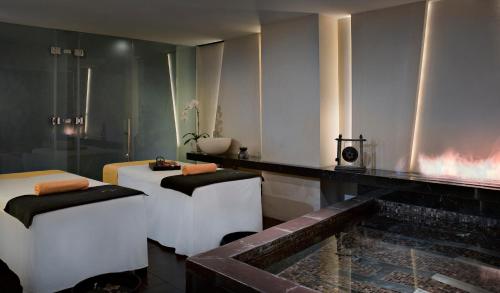 a bathroom with two beds and a bath tub at The Canvas Dubai - MGallery Hotel Collection in Dubai