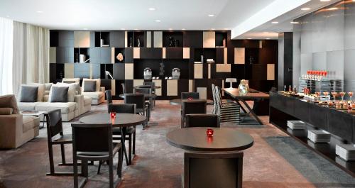 a hotel lobby with tables and chairs and a bar at The Canvas Dubai - MGallery Hotel Collection in Dubai