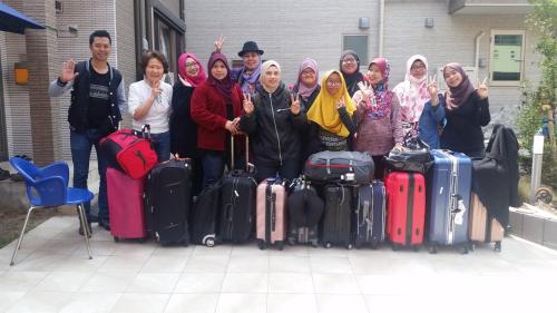 a group of people posing for a picture with their luggage at Tokyo Guest House 2020 in Tokyo