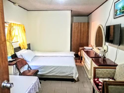 una camera con letto, TV e scrivania di Xia Xing Inn a Jinhu