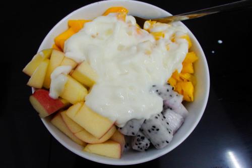 a bowl of cheese and fruit with a spoon at Ngọc Sinh Homestay in Hoi An