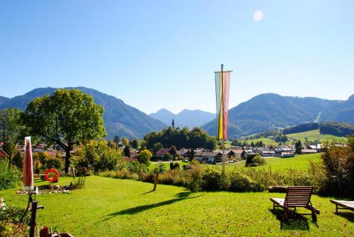 a park with benches in a field with mountains in the background at Gästehaus Schröder in Ruhpolding
