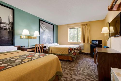 a hotel room with two beds and a desk at Super 8 by Wyndham Mentor/Cleveland Area in Mentor