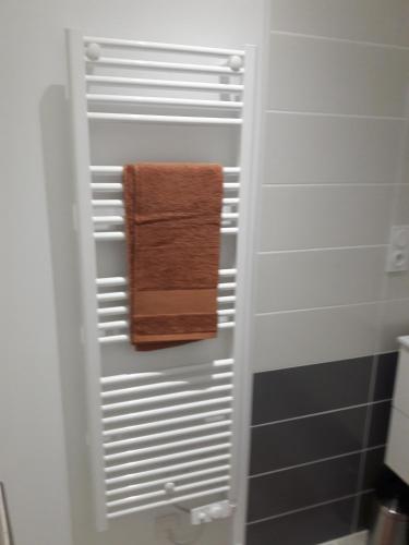 - une serviette suspendue à un porte-serviettes dans la salle de bains dans l'établissement Gîte Carnot, à Dompaire