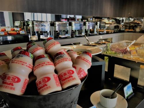 a bunch of milk bottles in a bucket in a kitchen at Hotel Lainn in Kaohsiung