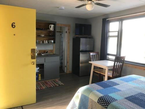 a room with a kitchen with a table and a yellow door at Jasper Way Inn Resort & Campground in Clearwater