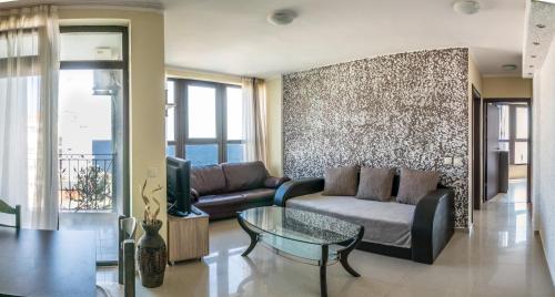 a living room with a couch and a glass table at Laguna Beach Apartments with Sea View in Ravda