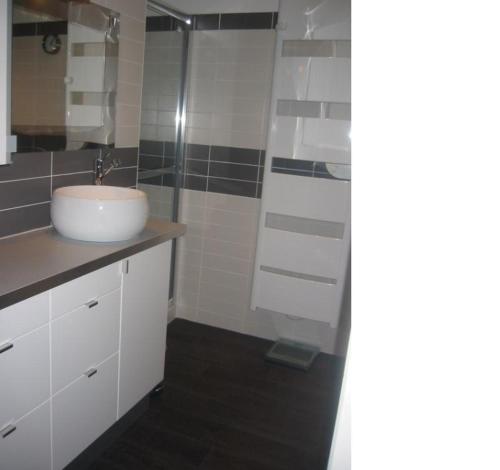 a bathroom with a sink and a glass shower at Maison de ville Royan centre - Meublé tourisme 4 étoiles in Royan