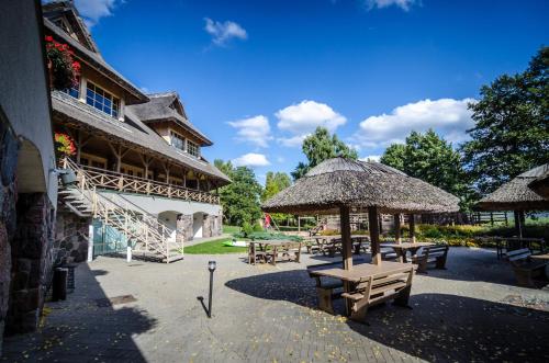a patio with tables and umbrellas in front of a building at Porto Resort in Lilaste