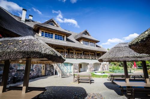 a large building with tables and straw umbrellas at Porto Resort in Lilaste