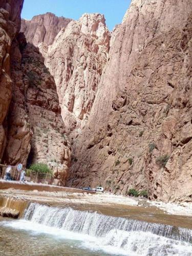 a waterfall in a canyon next to a mountain at Hotel Restaurant La Kasbah in Tinerhir