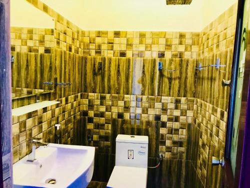 a bathroom with a sink and a toilet and a shower at Travellers Halt in Ratnapura