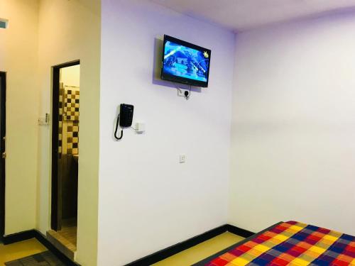 a room with a tv on a white wall at Travellers Halt in Ratnapura
