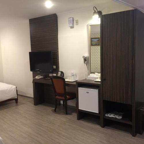 a room with a desk with a computer and a mirror at Kousin Hotel in Kaohsiung