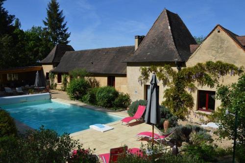 une maison avec une piscine devant une maison dans l'établissement Les Deux Tours, à Siorac-en-Périgord