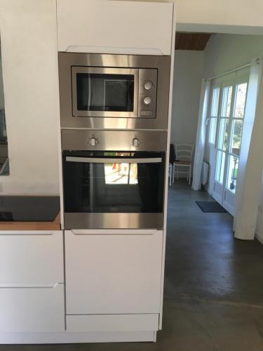 La cocina está equipada con horno de acero inoxidable y microondas. en Les Genets, en Ker borny