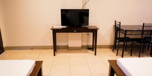 een kamer met een tafel en een televisie. bij Veranda Residence Inn in Tacloban