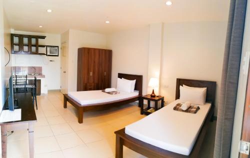 una camera d'albergo con due letti e una cucina di Veranda Residence Inn a Tacloban