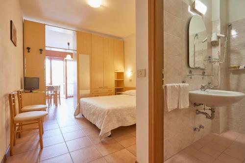 a bathroom with a bed and a sink in a room at Residence Piccolo in Milano Marittima