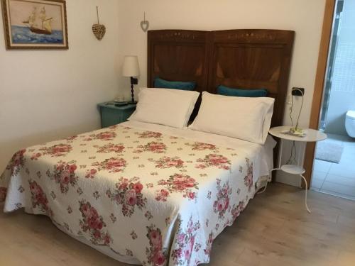 a bedroom with a bed with a floral bedspread at B&B Ai Castagni in Tenno
