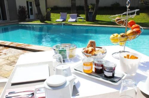 a table with a tray of food next to a pool at Villa Made in Saint-Tropez