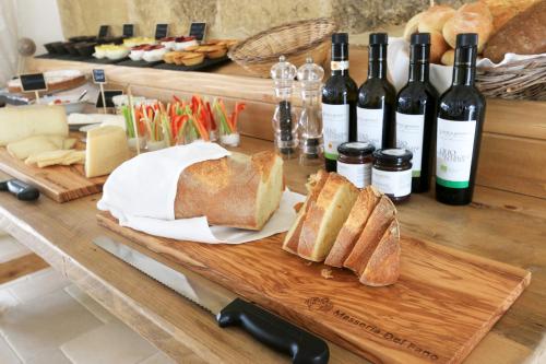 a table topped with bread and bottles of wine at Masseria Fano Relais & Wine in Salve