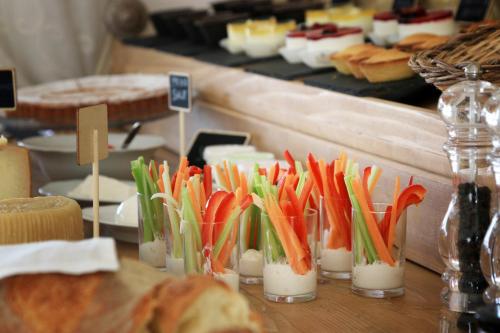 a table with several vases filled with vegetables and bread at Masseria Fano Relais & Wine in Salve
